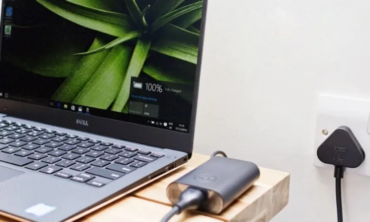 Hình ảnh laptop đang được cắm sạc trong khi người dùng làm việc